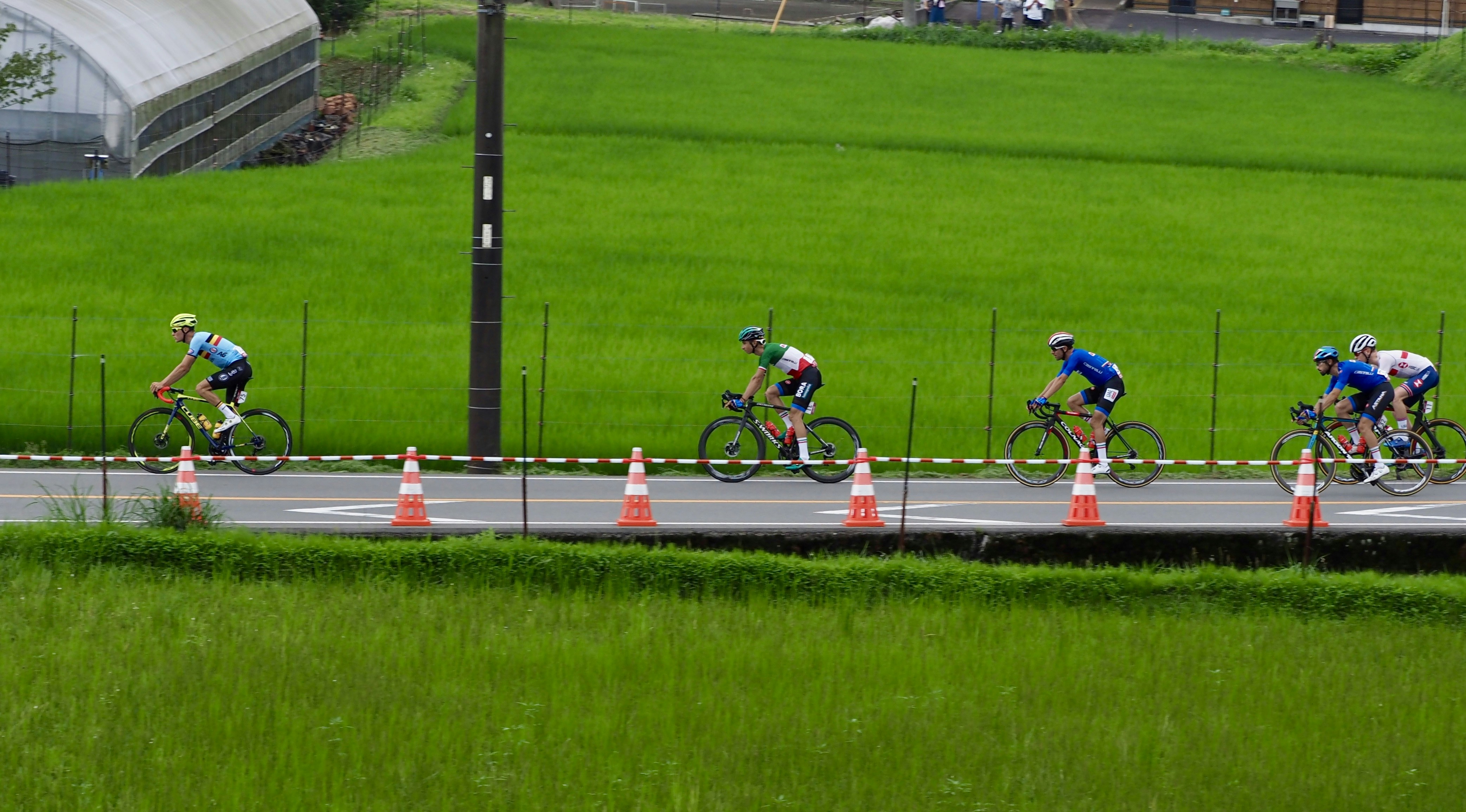 2 men riding bicycle on track field during daytime
