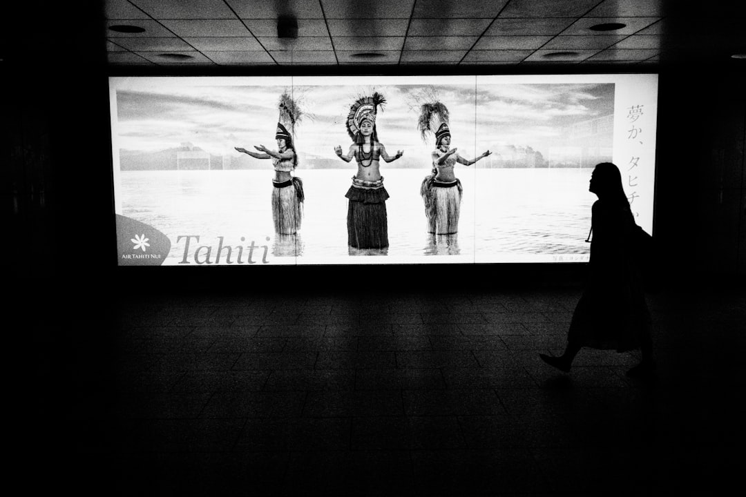 grayscale photo of 2 women standing in front of wall