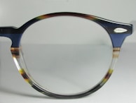 Close-up of a pair of classic black frames with subtle blue accents on the temples.