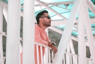 man in pink dress shirt wearing black sunglasses