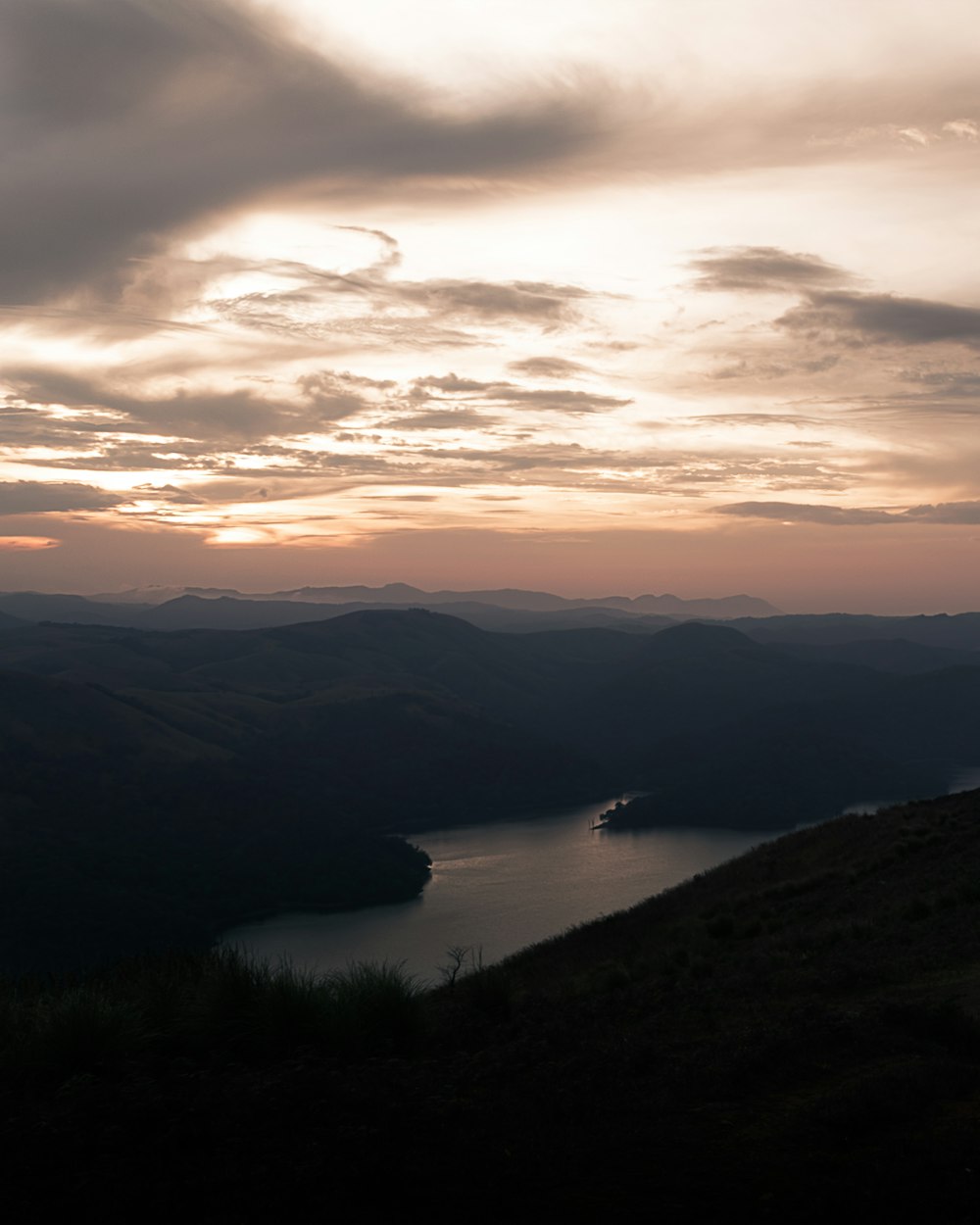 body of water between mountains during sunset