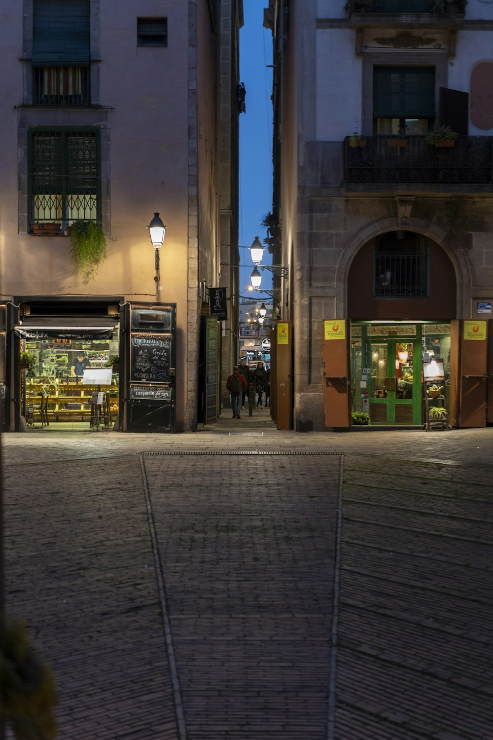 people walking on sidewalk near building during night time