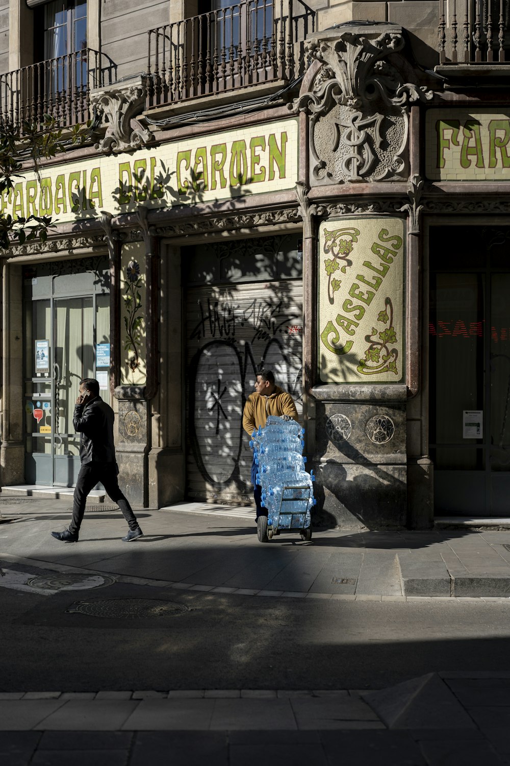 man in black jacket walking on sidewalk during daytime