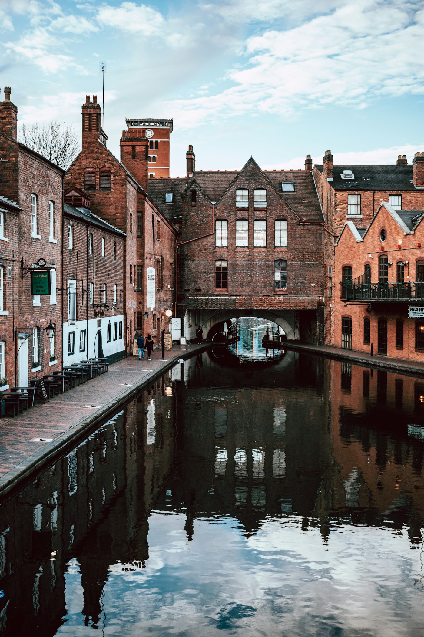A canal lined with old red-brick buildings in Birmingham on a summer day