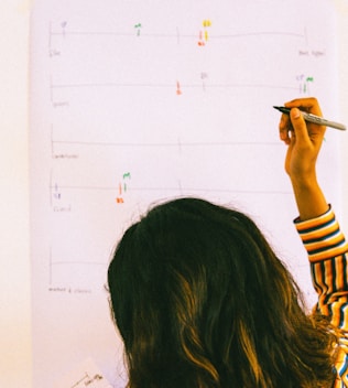 woman in yellow and black striped long sleeve shirt holding pen