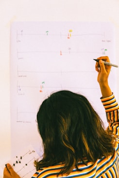 woman in yellow and black striped long sleeve shirt holding pen