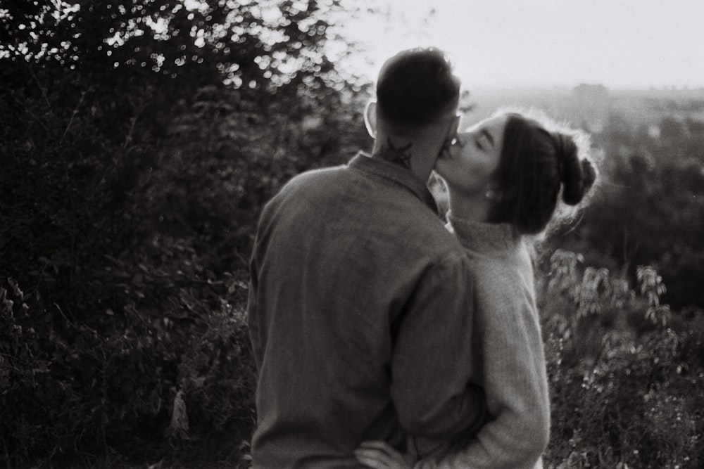 그레이스케일 사진에서 키스하는 남자와 여자