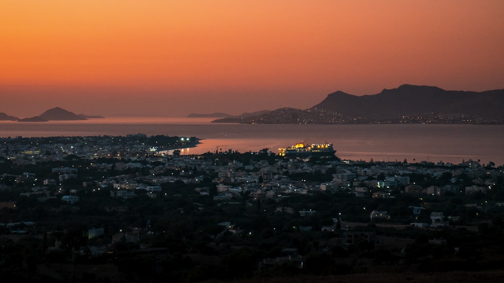 city skyline near body of water during night time