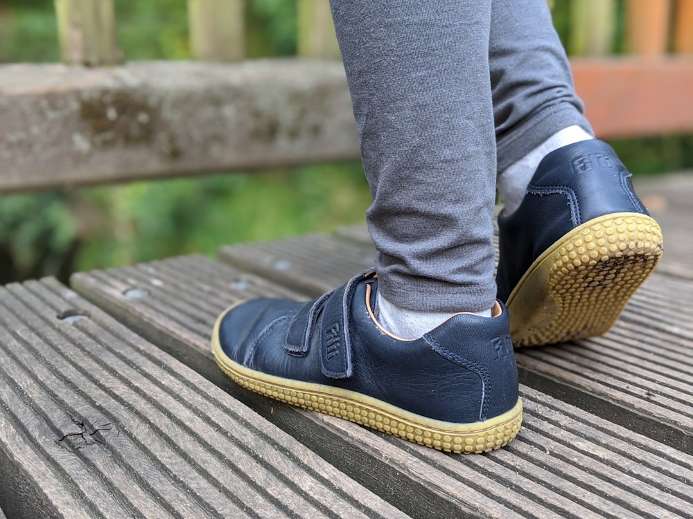 person in blue denim jeans and black and brown shoes