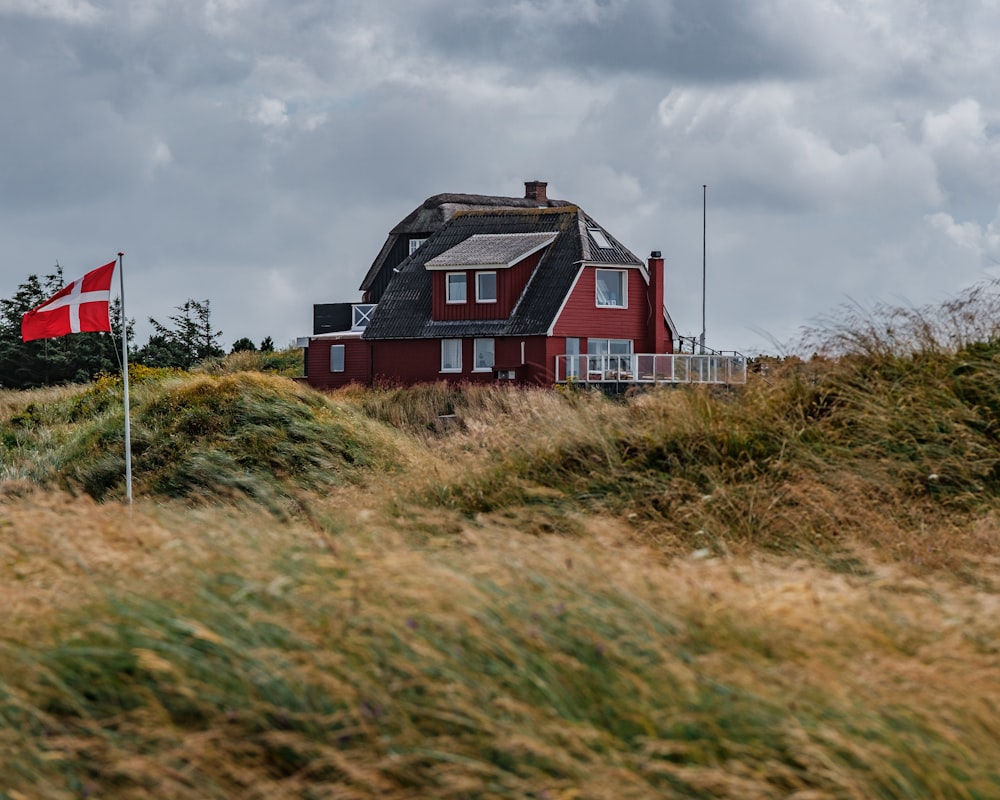 brown and black house near green grass field under white clouds during daytime