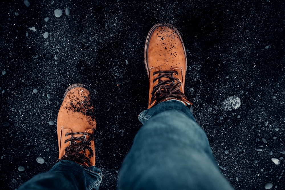 person in blue denim jeans and brown leather shoes