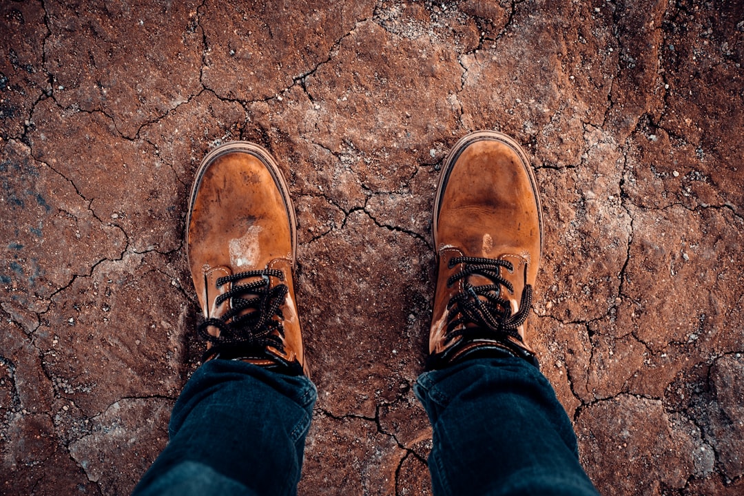 person in blue denim jeans and brown leather shoes