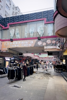 Casual shot of a male and female model wearing oversized hoodies, walking through a bustling market.