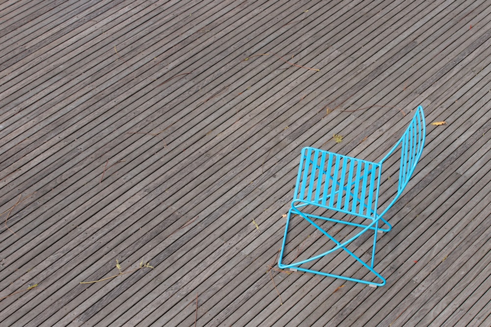 blue metal chair on brown wooden floor