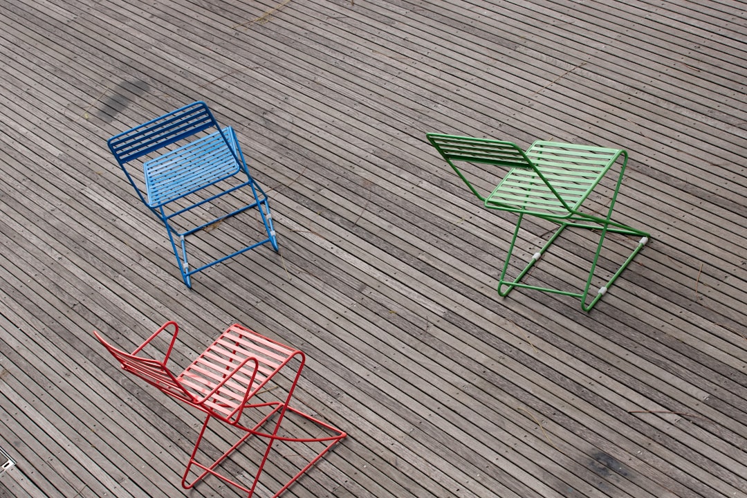 2 green and red folding chairs on gray wooden floor
