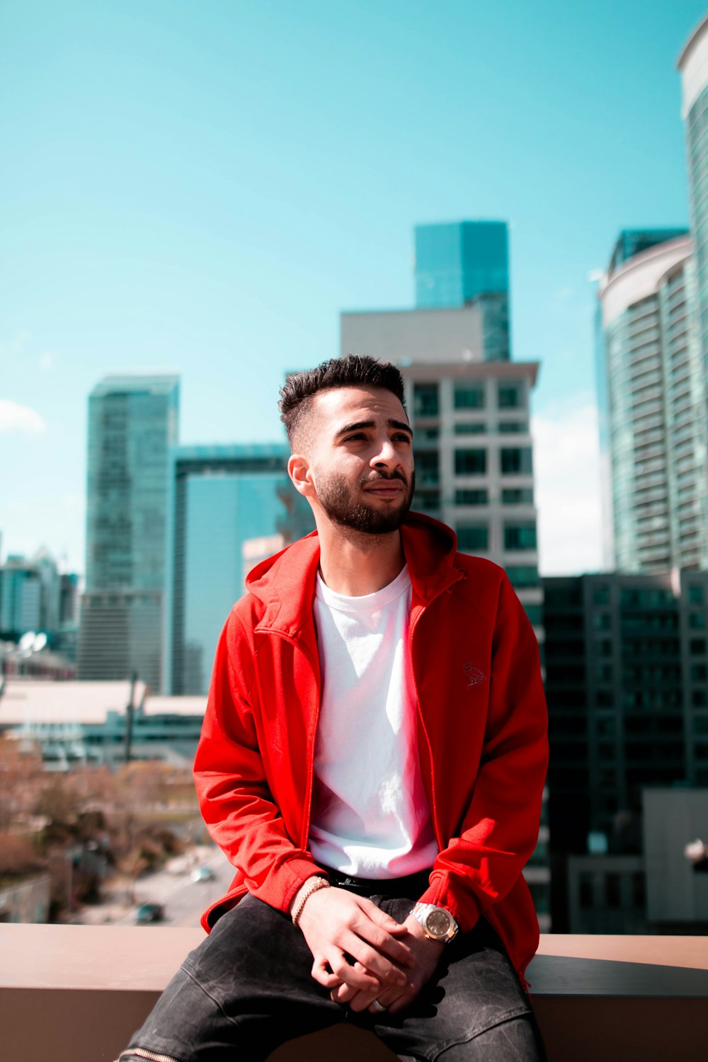 man in red zip up jacket standing near building during daytime