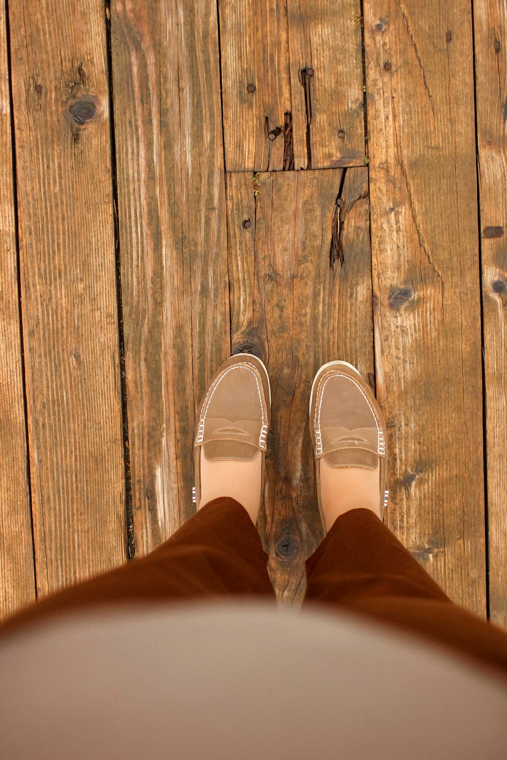 person in brown pants and white shoes