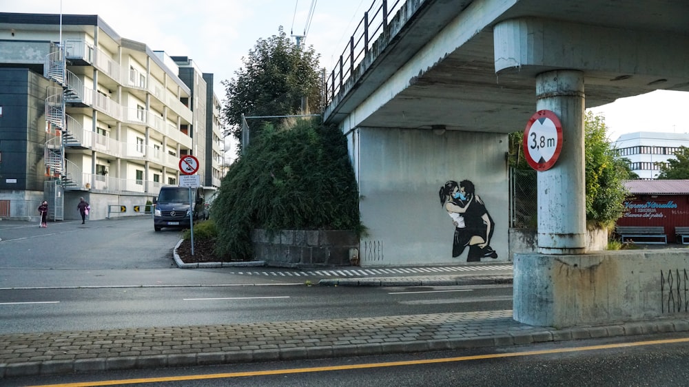 man in black jacket and black pants sitting on concrete wall during daytime