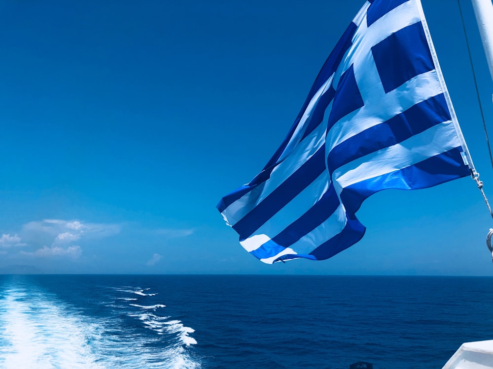 blue and white striped flag on the sea during daytime