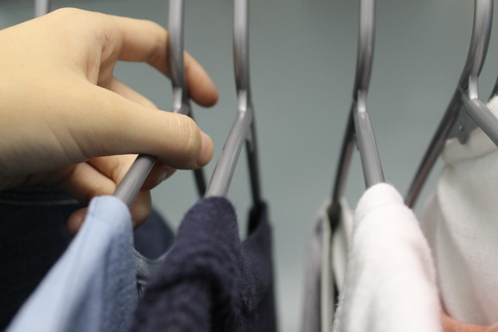 person holding white clothes hanger