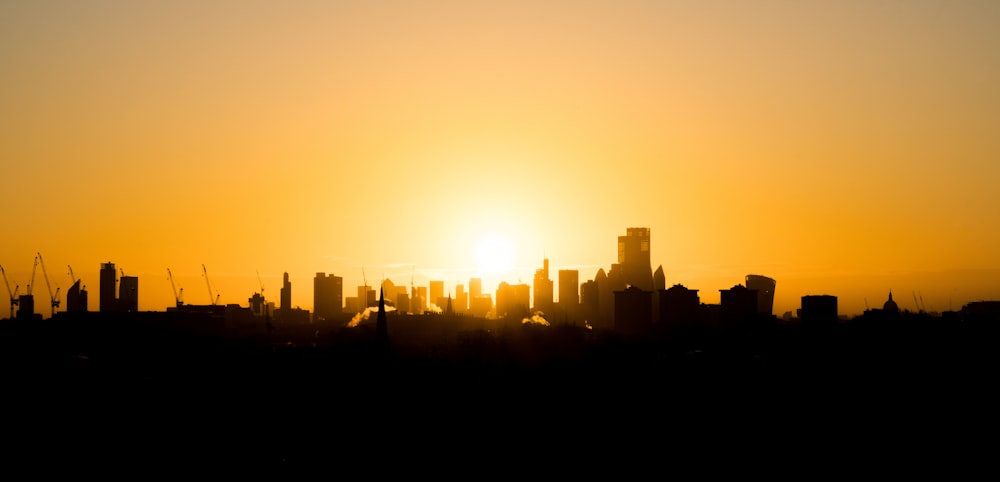 silhouette of city buildings during sunset