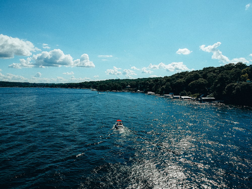 person in red shirt riding on red kayak on blue sea under blue sky during daytime