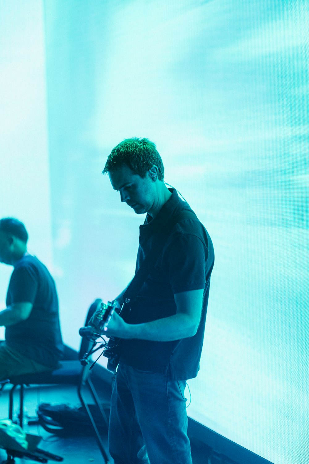 man in black polo shirt holding microphone