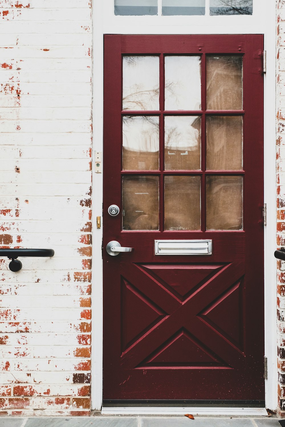 red wooden door with black steel door lever