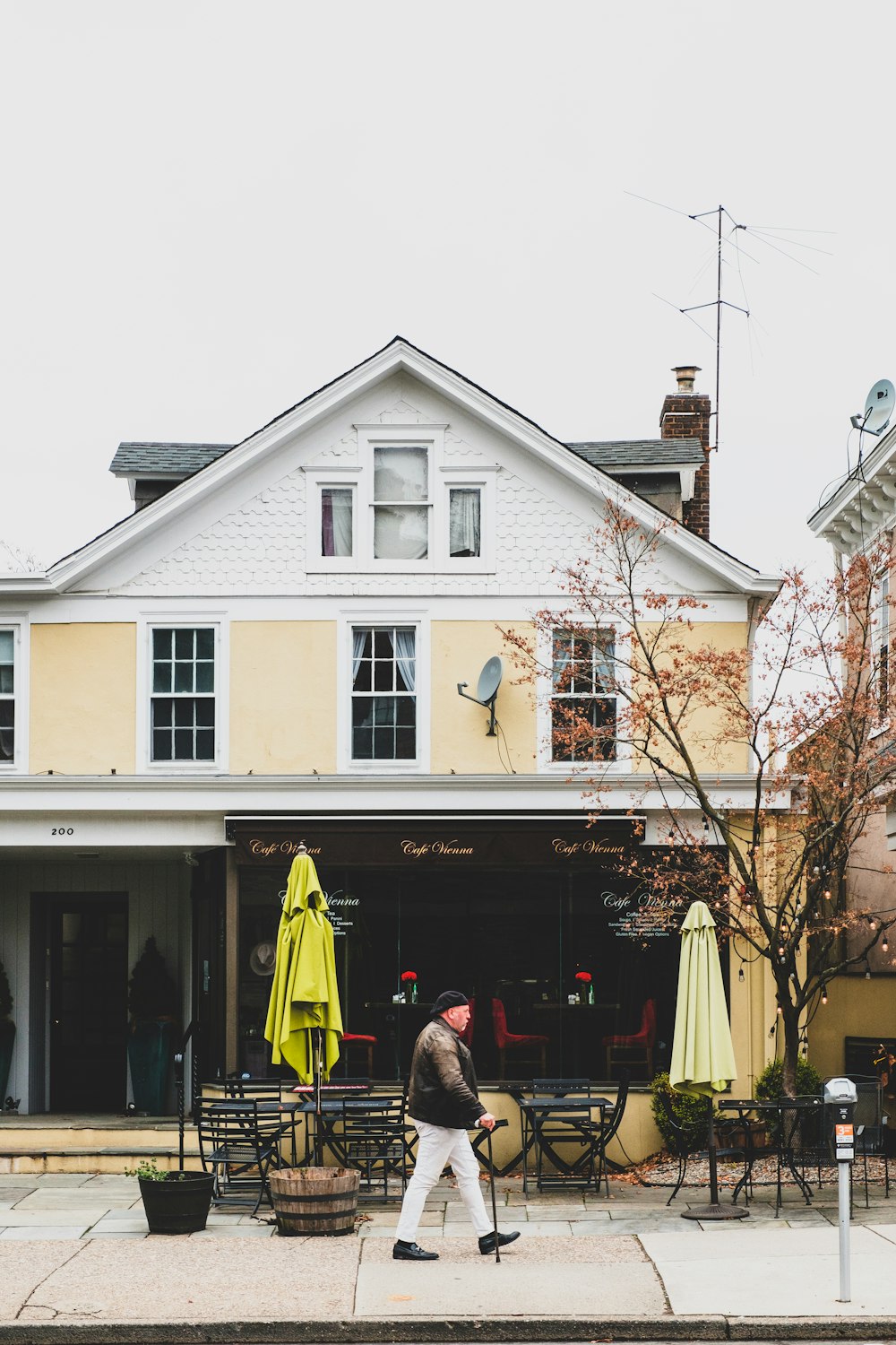 people walking near white and gray house during daytime