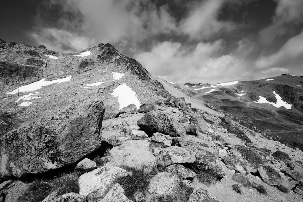 grayscale photo of mountain under cloudy sky