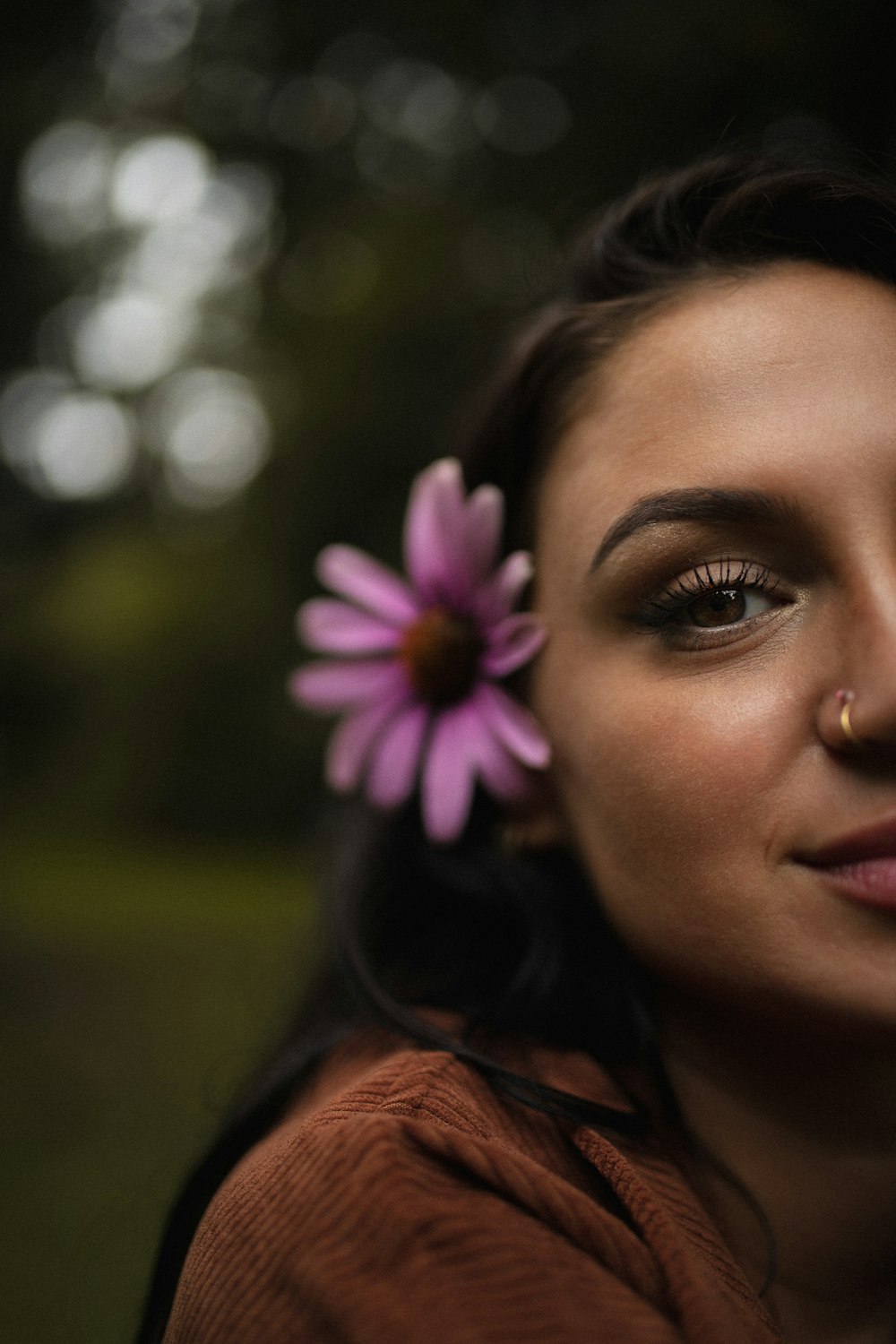 woman with pink and white flower on her ear