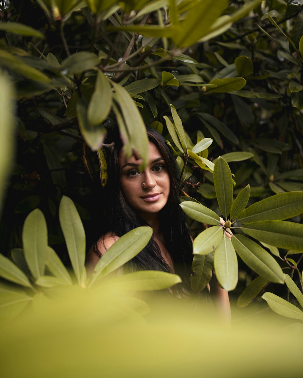 woman in yellow shirt standing beside green plant