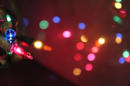 A close-up of colorful Christmas lights glowing at night.