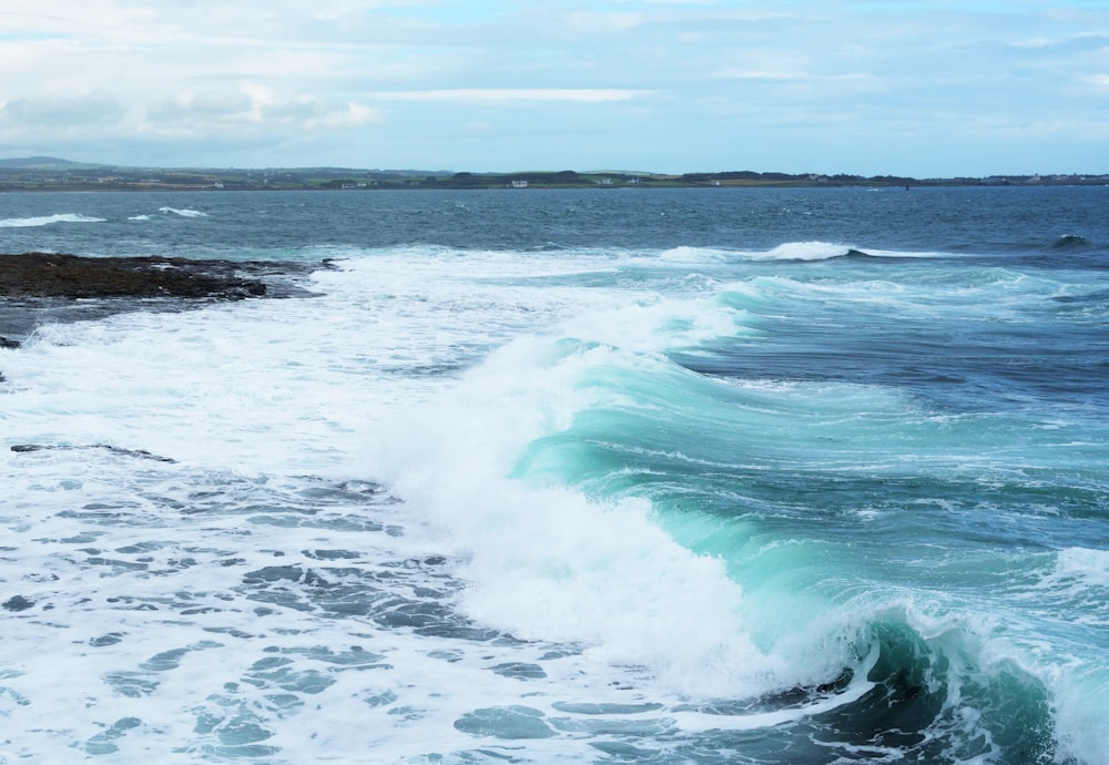 ocean waves crashing on shore during daytime