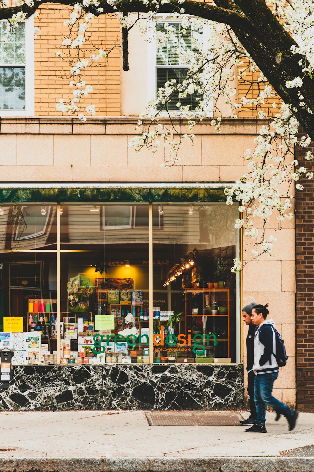 man in black jacket standing in front of store