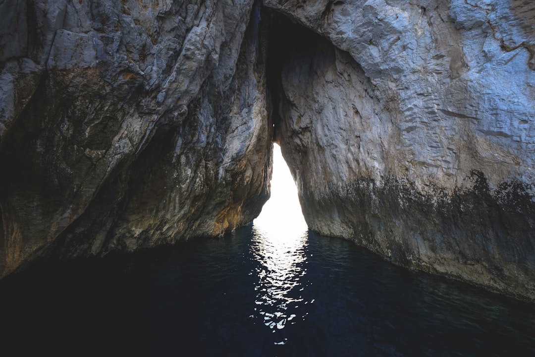 gray rock formation on body of water during daytime