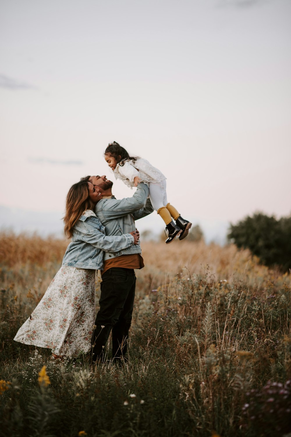 Hombre y mujer besándose en un campo de hierba marrón durante el día