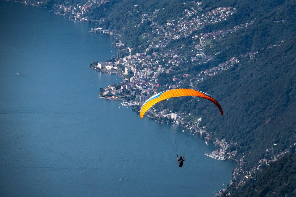 person in yellow parachute over blue sea during daytime