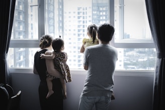 man and woman kissing in front of window during daytime