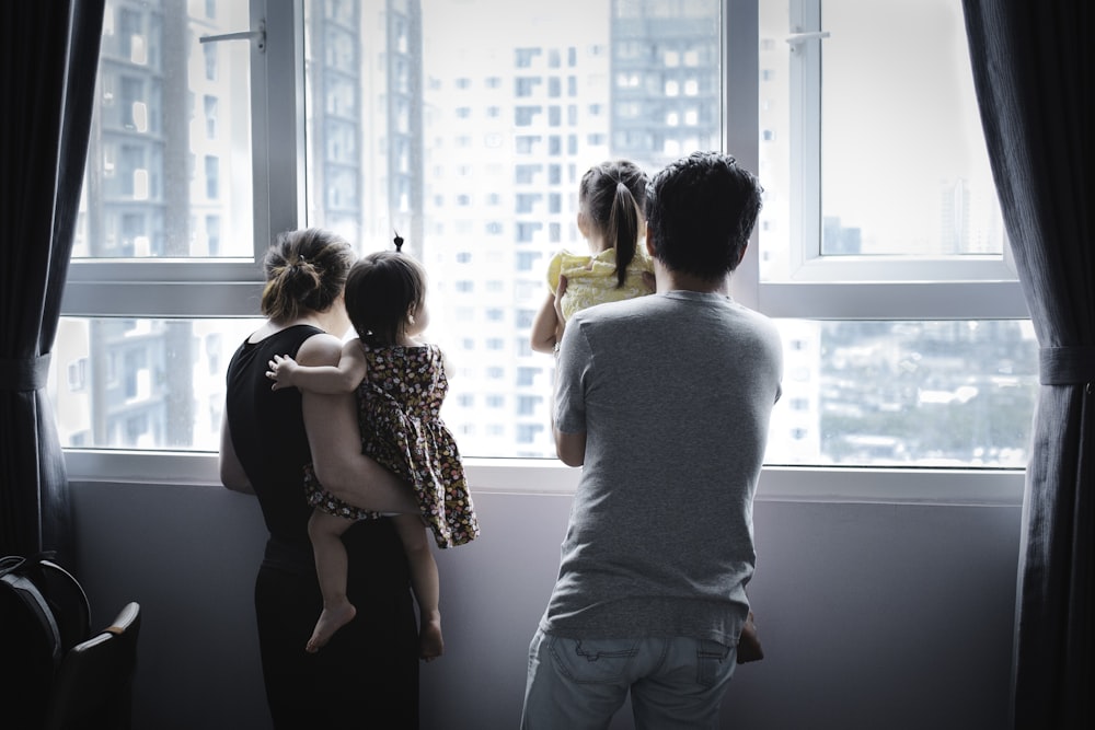 hombre y mujer besándose frente a la ventana durante el día