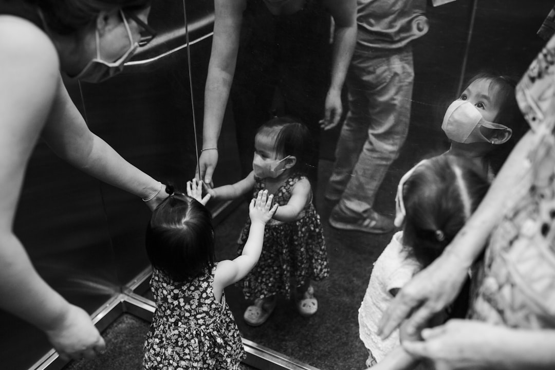 grayscale photo of woman in dress carrying baby