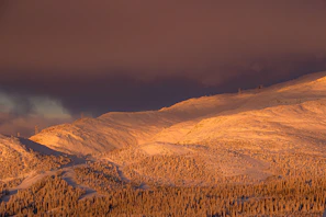 Sunrise casting golden light over the snowy peaks surrounding Saint Moritz lake