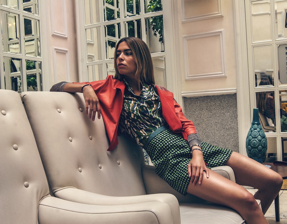 woman in red and black plaid dress shirt sitting on white leather armchair