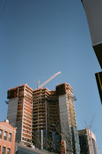 Steel framework of a multi-story building rising against a clear sky