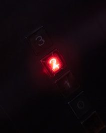Elevator control panel showing an emergency rescue button illuminated in red.