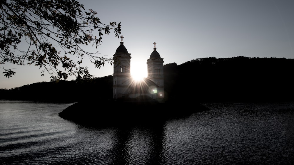 silhouette d’un bâtiment près d’un plan d’eau pendant la nuit