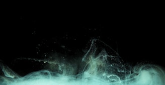 An abstract representation of swirling dark clouds with a hint of mint light.