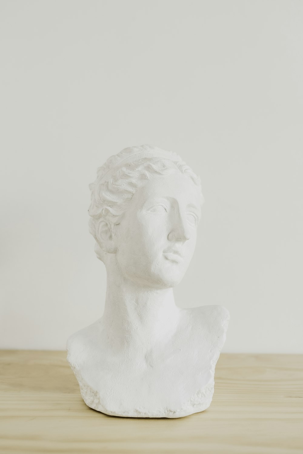 white ceramic statue on brown wooden table