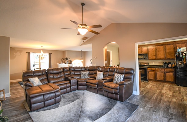 A stylish l-shaped faux leather sectional sofa in a warm living room setting.