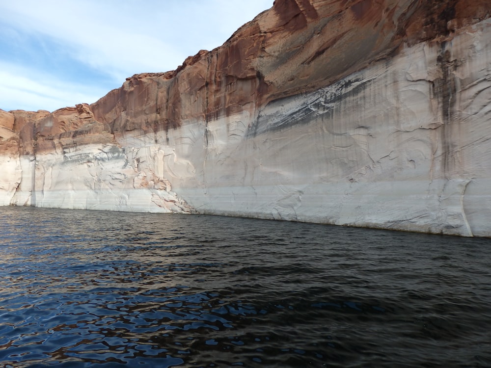 white and brown rock formation on body of water during daytime